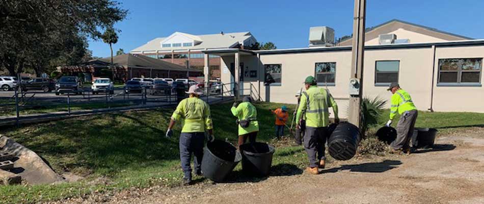 Our employees working at a commercial property in Lakeland, FL, cleaning up yard debris..